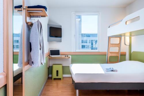 克莱蒙费朗Ibis Budget Clermont Ferrand - Le Brezet - Aeroport的客房配有1张床和1张双层床。