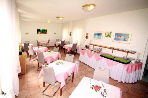 巴特哈尔茨堡菲丝别墅的餐厅配有桌椅和粉红色的桌布