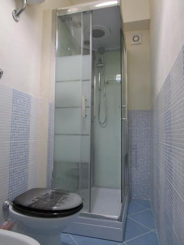 雷阿尔蒙特Playa Dei Turchi的浴室设有玻璃淋浴间和卫生间