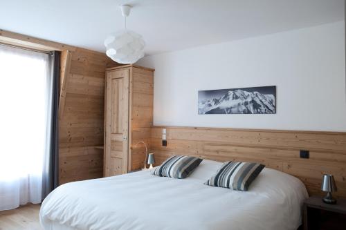 夏蒙尼-勃朗峰卡尔兹蒙布兰科酒店的卧室设有一张白色大床和一扇窗户。