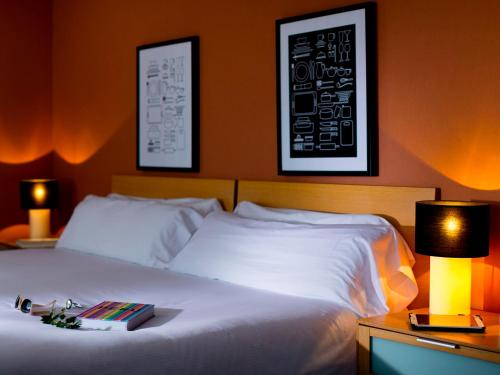 卡尔佩库克布科美食精品酒店及SPA的一间卧室,配有一张带两盏灯的床,并备有一本书