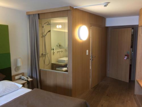 格蒙登施万湖滨酒店的一间卧室配有一张床,浴室设有水槽