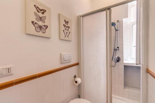 罗马AwesHomeItaly - Spagna Glamour Life Penthouse的浴室设有卫生间和墙上的蝴蝶淋浴。