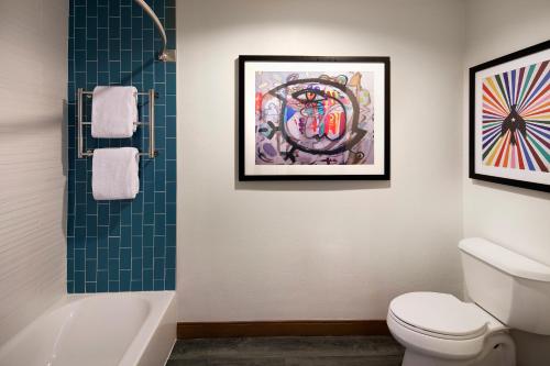 洛杉矶肯尼 - 威尼斯海滩酒店的一间带卫生间的浴室和墙上的绘画