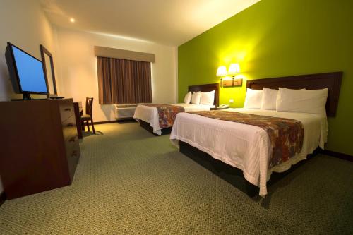 维多利亚城布里奥酒店的酒店客房设有两张床和一台平面电视。