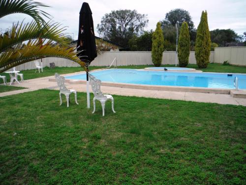 巴瑟尔顿热斯塔威尔汽车旅馆的游泳池旁草地上的两把椅子