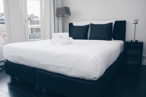 阿姆斯特丹运河住宿加早餐旅馆的一张配有白色床单和蓝色枕头的大床