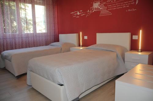 斯培西亚拉佩尔拉住宿加早餐旅馆的卧室设有两张床铺和红色的墙壁