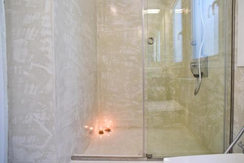 圣马太奥斯Mavres Luxury Studio的玻璃门淋浴,里面放着蜡烛