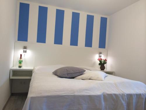 朱列斯拉赫Ferienzimmer Lütt的卧室配有一张带蓝色和白色条纹的床铺。