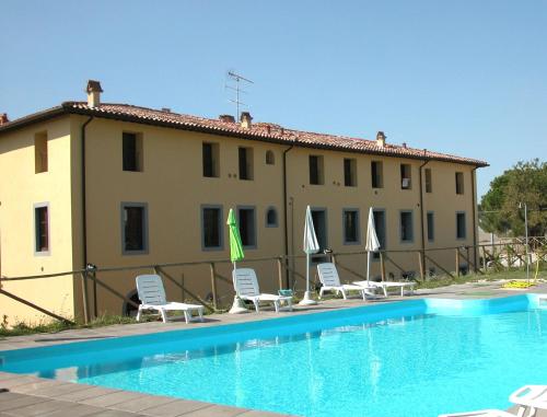 Pieve di Santa LuceResidence Giuly Rosselmini的酒店设有带椅子和遮阳伞的游泳池