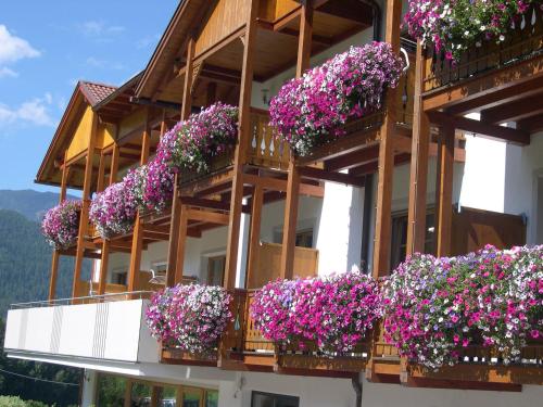 圣洛伦佐-迪塞巴托琳娜霍夫酒店的一座在阳台上种满鲜花的建筑