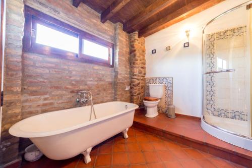 Alquerías del Niño PerdidoVilla Rotonda的一间带白色浴缸和砖墙的浴室
