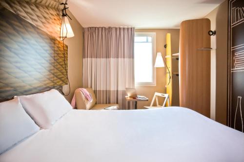 圣但尼ibis Paris Saint-Denis Stade Sud的酒店客房,配有白色的床和椅子