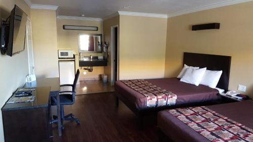 安纳海姆Anaheim Astoria Inn & Suites的酒店客房配有两张床和一张书桌