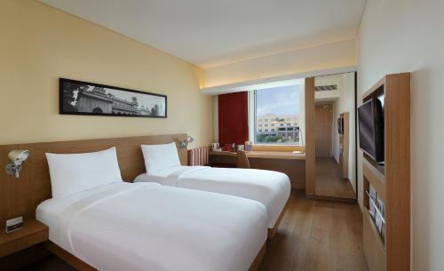 海得拉巴ibis Hyderabad Hitec City - An Accor Brand的酒店客房设有两张床和电视。