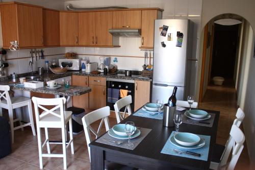 洛斯克里斯蒂亚诺斯海滩度假屋的厨房配有桌椅和冰箱。