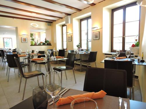 沃韦奥伯格康姆纳尔圣勒日酒店的用餐室设有桌椅和窗户。