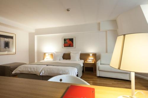 卢森堡西蒙奇尼酒店的配有一张床和一把椅子的酒店客房