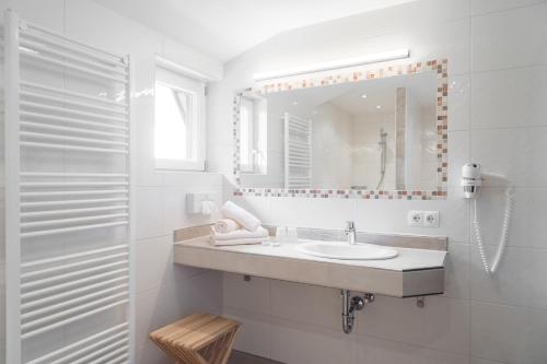 拉姆绍达赫斯坦Gasthof Edelbrunn的白色的浴室设有水槽和镜子