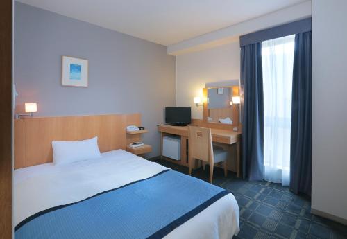 埼玉市浦和华盛顿酒店的配有一张床和一张书桌的酒店客房