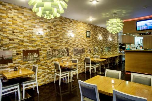阿姆斯特丹拉兰特酒店的一间带桌椅的餐厅以及砖墙