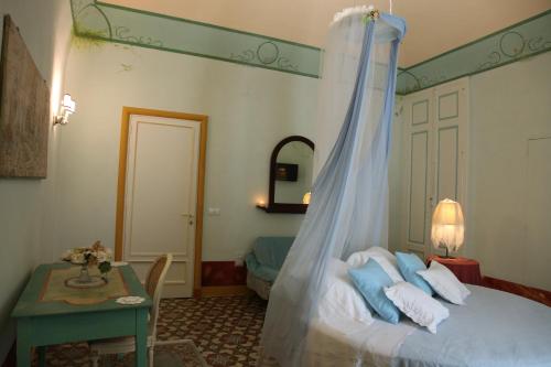 科拉托Locus Amoenus Luxury Rooms的一间卧室配有一张带天蓬和桌子的床