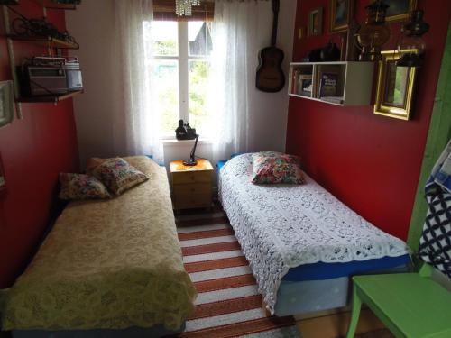 MaxmoGula Villan的宿舍间的两张床,设有红色的墙壁和窗户。