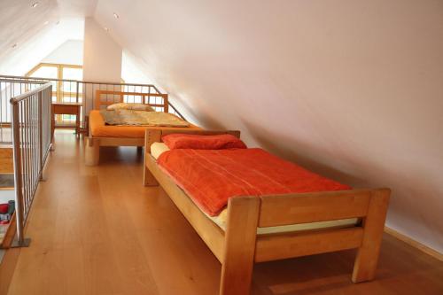 慕尼黑达赫嘎勒瑞公寓的一间卧室配有两张带橙色床单的床