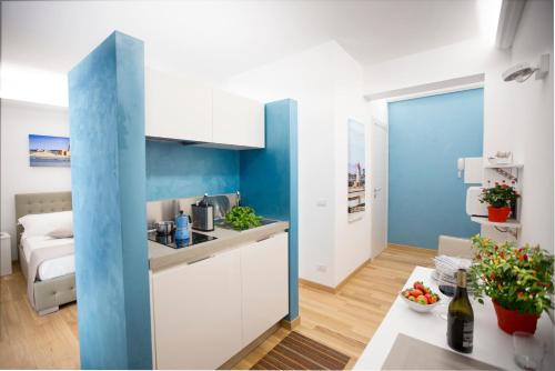 特拉帕尼Appartamenti Trapani In的厨房配有白色橱柜和蓝色的墙壁