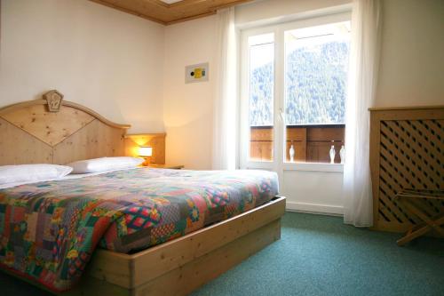 维哥迪法萨西玛多迪西酒店的一间卧室设有一张床和一个大窗户
