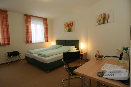 维也纳卡斯帕膳食公寓酒店的一间卧室配有一张床和一张书桌及电话