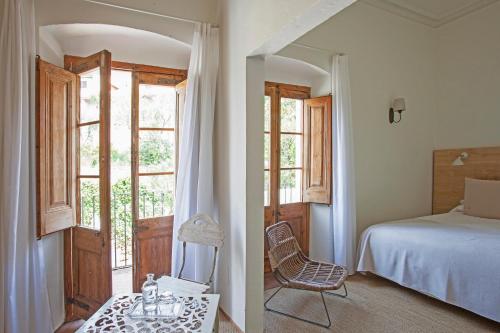 巴古尔河内酒店的卧室配有床、椅子和窗户。