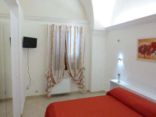 梅林Casa Gianni的一间卧室设有红色的床和窗户。