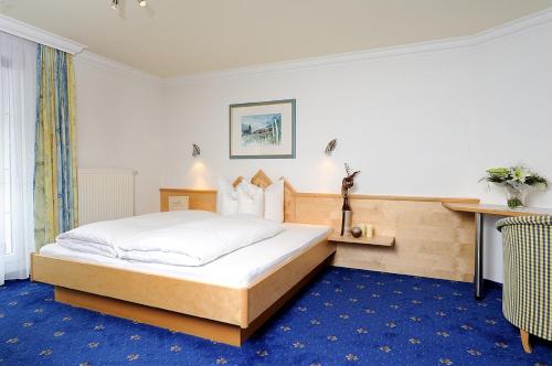 伊施格尔Hotel Garni Valülla的一间卧室配有一张床,铺有蓝色地毯