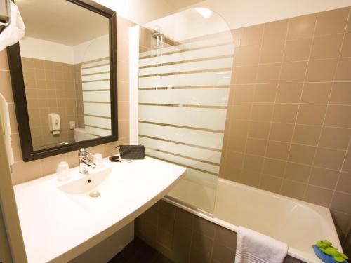 南特宜必思式南特中心皇家广场酒店的浴室配有盥洗盆、镜子和浴缸