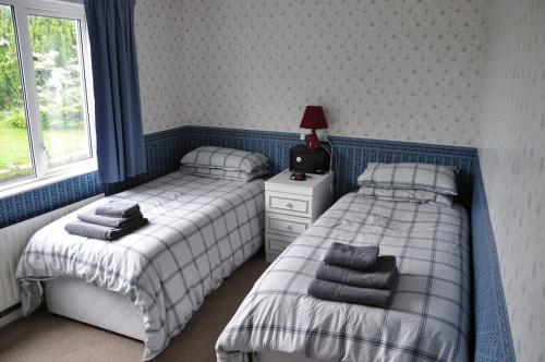 DonagheyEaglesfield House Guest Apartment的一间卧室配有两张床和床头灯。