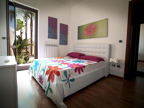 莱切Appartamento Paolo的卧室配有带鲜花的白色床