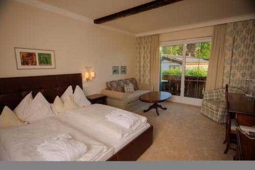德布里阿赫Romantik SPA Hotel Seefischer的酒店的客房 - 带一张床、椅子和窗户