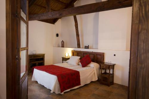 贝尔蒙特Casa Rural Casona la Beltraneja的一间卧室配有一张带红色毯子的床