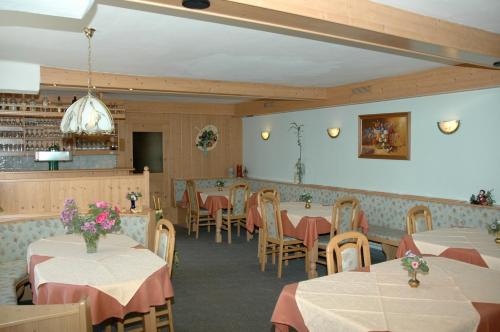 Gnesau菲尔恩娃林萨腾膳食公寓酒店的用餐室配有桌椅和粉红色的桌布