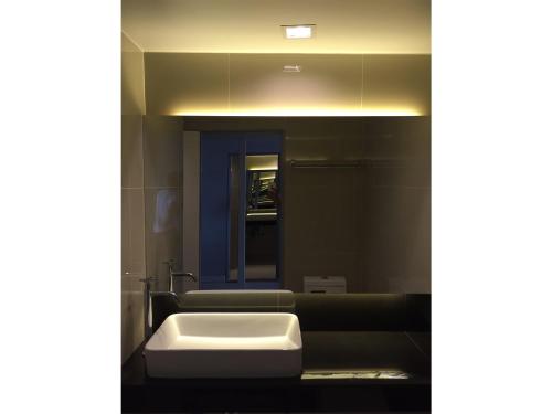 华欣华欣码头公寓的一间带白色水槽和沙发的浴室