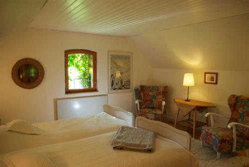VeberödTrolleberg Bed & Breakfast的卧室配有一张床和一张桌子及椅子