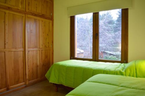 拉安戈斯图拉镇La Araucaria的客房设有两张床和大窗户。