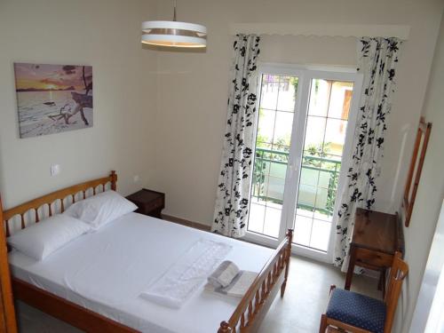 莫拉蒂卡Tassos Village House的卧室配有白色的床和窗户。