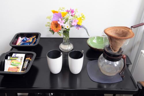 马斯特里赫特乐居酒店的一张带鲜花的黑色桌子和花瓶