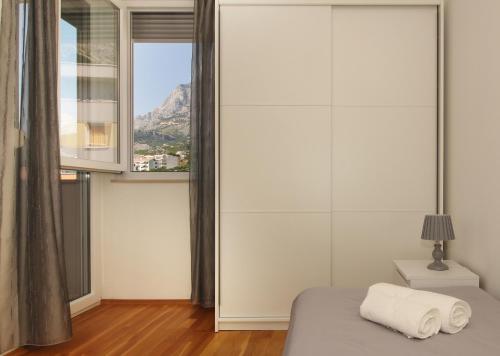 马卡尔斯卡Apartment Vista Makarska的一间卧室设有一张床和一个大窗户