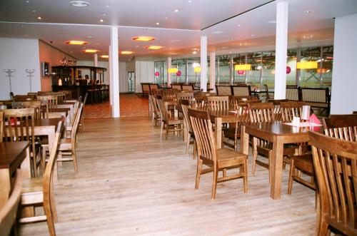 图库姆斯图库马乐杜思哈勒酒店的用餐室配有木桌和椅子