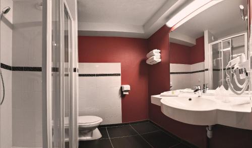 Saint-Barthélemy-dʼAnjou昂热王牌酒店的一间带红色墙壁、卫生间和水槽的浴室