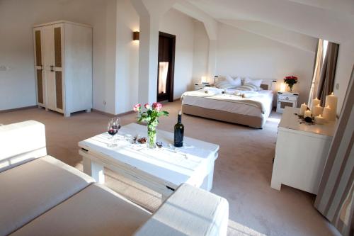 阿普里尔齐帕阿维恩酒店的一个大客厅,配有两张床和一张鲜花桌